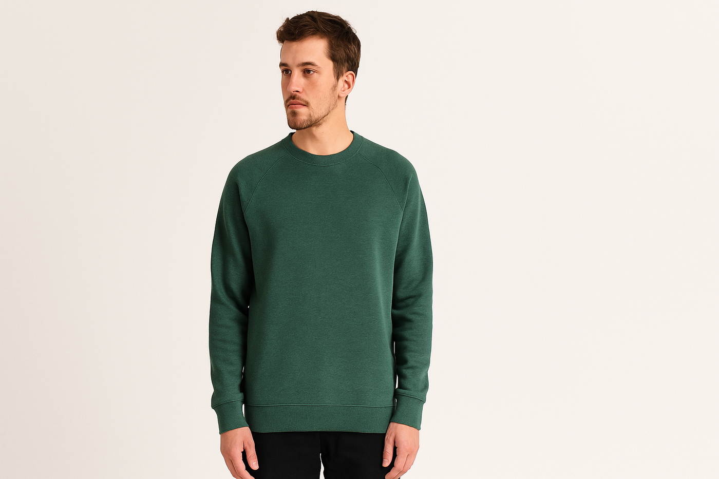 Junger Mann trägt einen grünen fairen Pullover aus Bio-Baumwolle vor neutralem Hintergrund – vegane, nachhaltige Herrenmode.