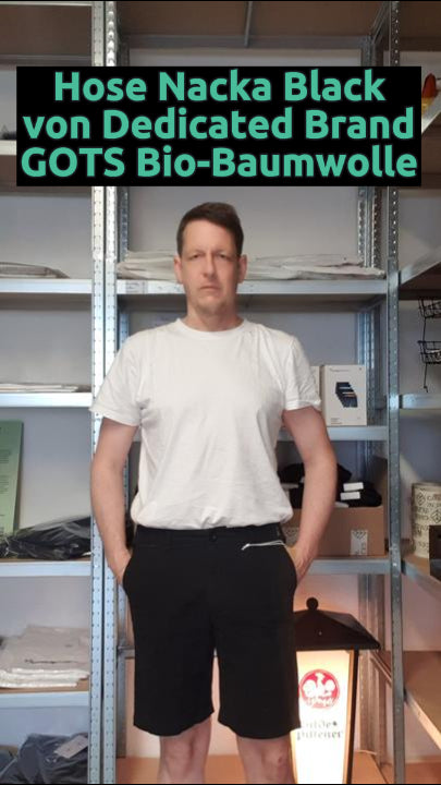 Daniel trägt die nachhaltige Chino Shorts Nacka in Schwarz von Dedicated Brand – aus Bio-Baumwolle, fair produziert, bequem und ideal für warme Tage.