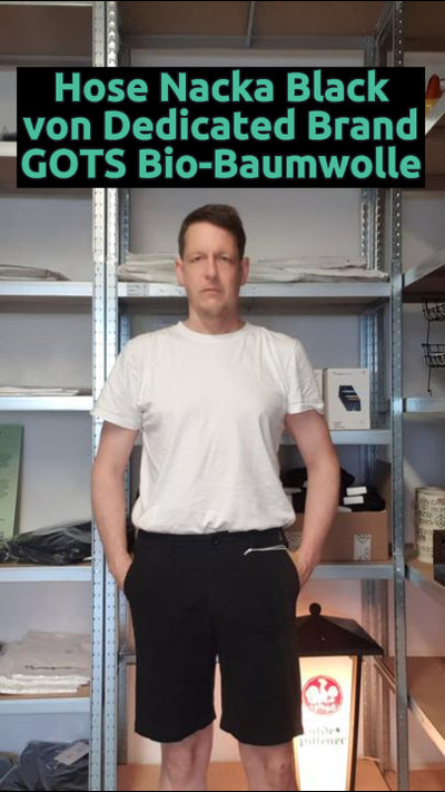 Daniel trägt die nachhaltige Chino Shorts Nacka in Schwarz von Dedicated Brand – aus Bio-Baumwolle, fair produziert, bequem und ideal für warme Tage.