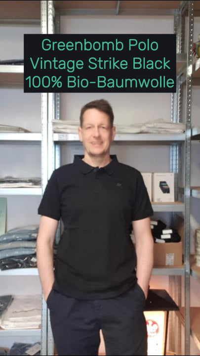 Daniel trägt das nachhaltige Polo Bike Vintage Strike in Schwarz von Greenbomb – aus Bio-Baumwolle, fair produziert und angenehm atmungsaktiv.