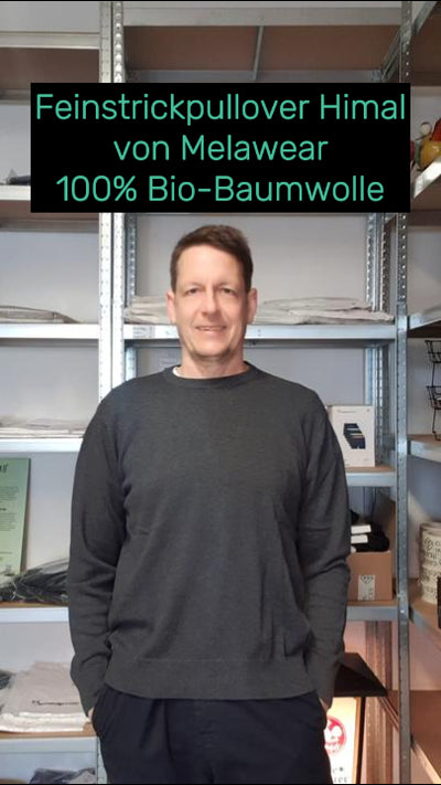 Daniel trägt den nachhaltigen Feinstrick Pullover Himal in Grau von Melawear – aus weicher Bio-Baumwolle, fair produziert und angenehm auf der Haut.