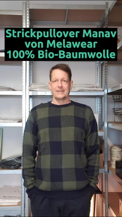 Daniel trägt den nachhaltigen Jacquard Strickpullover Manav Navy Karo von Melawear – fair produziert aus Bio-Baumwolle, angenehm weich und zeitlos modern.